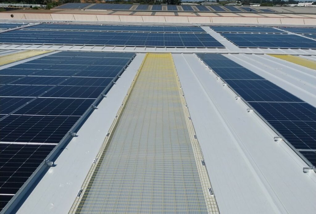 Malla o red de seguridad en altura en cubierta industrial lucernario y placas solares
